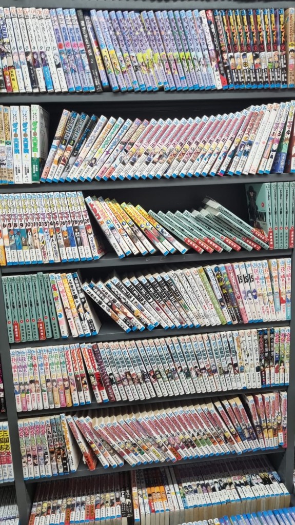 Japonya'da bir kitapçı veya Don Quijote tarzı mağazada raflara dizilmiş manga kitapları.