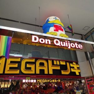 Tokyo’da MEGA Don Quijote mağaza girişi; Donpen maskotu ve ışıklı tabela.